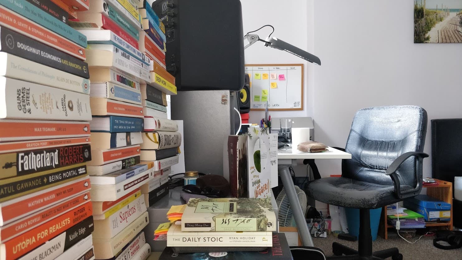Books stacked up with a desk in the background